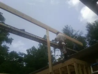 Carpenter setting a ridge beam over a new addition frame — Ice Dam Removal by Roofing Brothers in Landisville