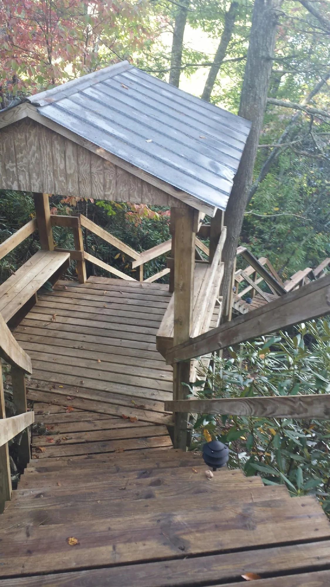 Metal roofed shelter over wooden steps on a wooded walkway — Skylight Repair & Installation work by our crew in Landisville
